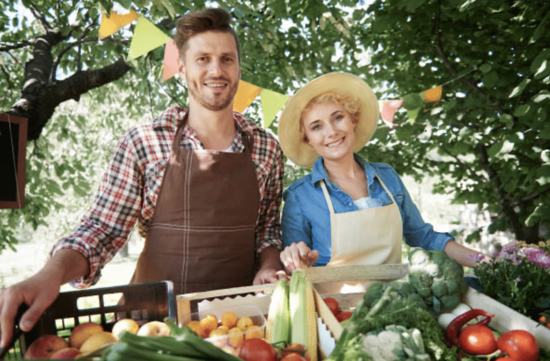 A lovely couple holding their vegetable they harvested at the farm